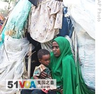 A Somali woman and her child sit in front of a makeshift home after they fled fighting in Mogadishu, 09 Jun 2009