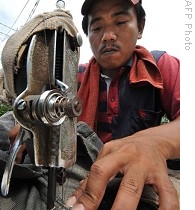 Indonesian street tailor works on his portable sewing machine in Jakarta, 02 Jun 2009<br />