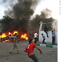 Supporters of defeated Iranian presidential candidate Mir Hossein Mousavi attack a local base of the Islamic Basij militia outside the base in Tehran, 15 June 2009