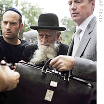 Rabbi Saul Kassin (C) leaves federal court in Newark, N.J., 23 Jul 2009 