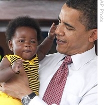 President Barack Obama holds a baby while visiting the La General Hospital in Accra, 11 Jul 2009