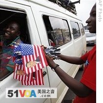 Street vendor sells US flags to public transport driver caught in traffic, in central Accra, 09 Jul 2009