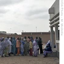 Voters outside Maurtiania's capital wait to cast their ballots in an election meant to restore constitutional rule following last year's coup, 18 Jul 2009