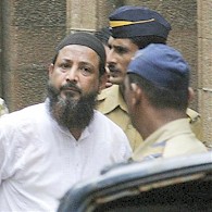 Syed Mohammed Haneef Abdul Rahim, left, one of people found guilty in 2003 Mumbai bombings, is escorted by policemen outside Mumbai court, 06 Aug 2009 