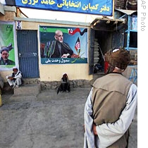 A man in Kabul passes an election poster of Afghan presidential candidate and current Pres. Hamid Karzai, 14 Aug 2009