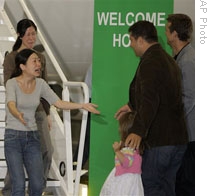 Euna Lee, in light shirt, and Laura Ling reunite with their families at the Burbank, California, airport