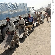 Afghan men wait in line to recieve staple goods during the distribution of food from the World Food Programme (WFP) in Kabul (File)
