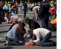 Bystanders give first aid to victims hit by a speeding car during Queen's Day celebrations in Apeldoorn, Netherlands, on April 30