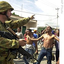 An Australian soldier talks to angry East Timorese men in Dili, capital of East Timor, 28 Jun 2006