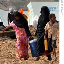 Displaced Yemenis from the northern Saada province carry water to their tent at a camp set up by the United Nations High Commissioner for Refugees in Mazraq in Hajja region, 10 Sep 2009