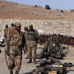 Pakistani army troops stand beside weapons and ammunitions confiscated from militants after a gunbattle in Ladha, a town in the Pakistani troubled tribal region of South Waziristan