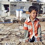 A Palestinian boy sits on rubble in an area destroyed during Israel's January 2009 Gaza offensive, 16 Jan 2010