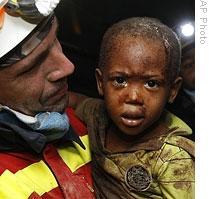 A Spanish rescuer carries 2-year-old Redjeson Hausteen Claude from a wrecked home in Port-au-Prince Thursday