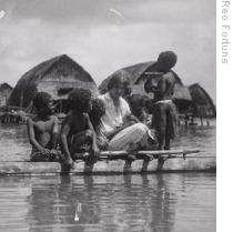 Margaret Mead in 1928 on a canoe with children on Manus island, in what is now part of Papua New Guinea 