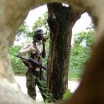 A Islamic fighter is seen through a hole caused by shrapnel in a wall, in Mogadishu, Somalia (File)