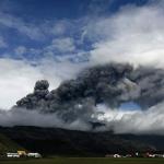Farms are dwarfed by a plume of ash rising from a volcano erupting under the Eyjafjallajokull glacier, as seen from Hvolsvollur, Iceland, 5 May 2010