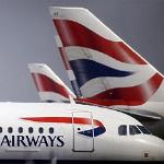 British Airways planes are seen behind fencing at Heathrow airport in London, Friday, 21 May 2010