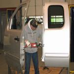 A worker prepares a GMC door to be attached to the lift.