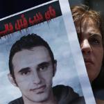 An activist carries a picture of slain Khaled Said during a protest in Cairo, 19 Jun 2010