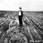 Hugh Haskell Bennett stands in a heavily eroded farm field near Haskell, Oklahoma, in 1943.