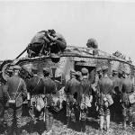 German soldiers standing around a German tank as other soldiers make repairs