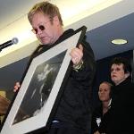 Elton John holds auction item for HIV/AIDS fund raiser (Billy Jean King far right)
