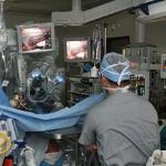 A surgeon performs an operation using robotic assistance