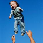 Andrei Balta throws his 15-month-old son Vanya in the air during a summer evening in Slavutych, Ukraine